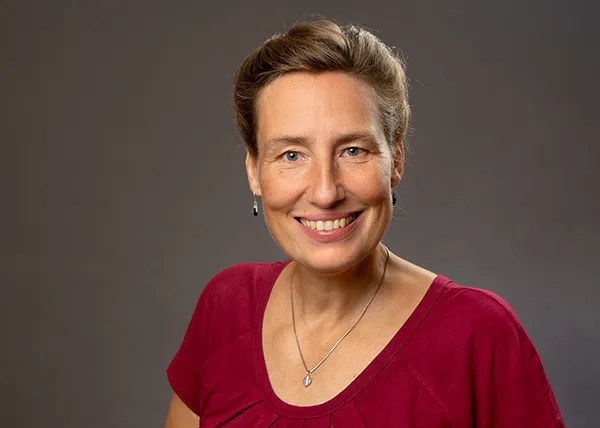 Porträt von Fotografin Eva Heisenberg im Fotostudio vor grauem Hintergrund in Rostock