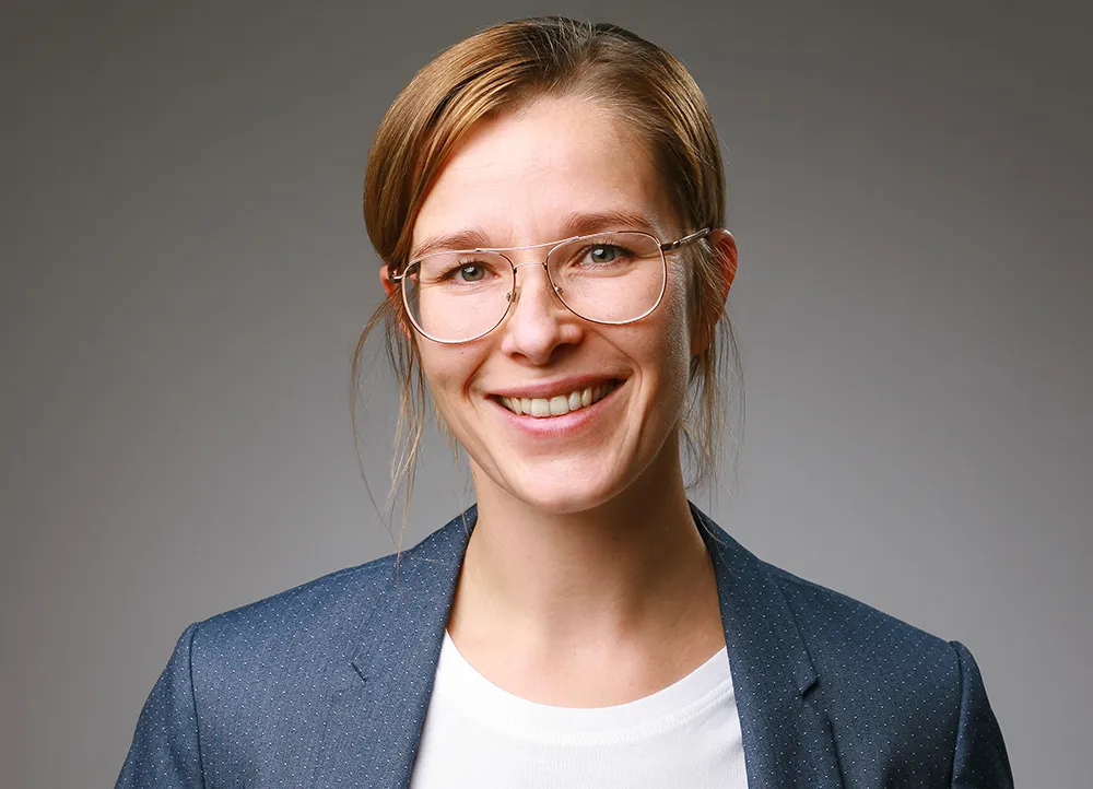Bewerbungsfoto einer Frau mit Brille vor grauem Hintergrund – professionelles Pass- und Bewerbungsfoto im Fotostudio Foto Ape Rostock